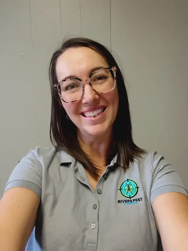 A smiling member of the Rivers office team in a grey logo polo